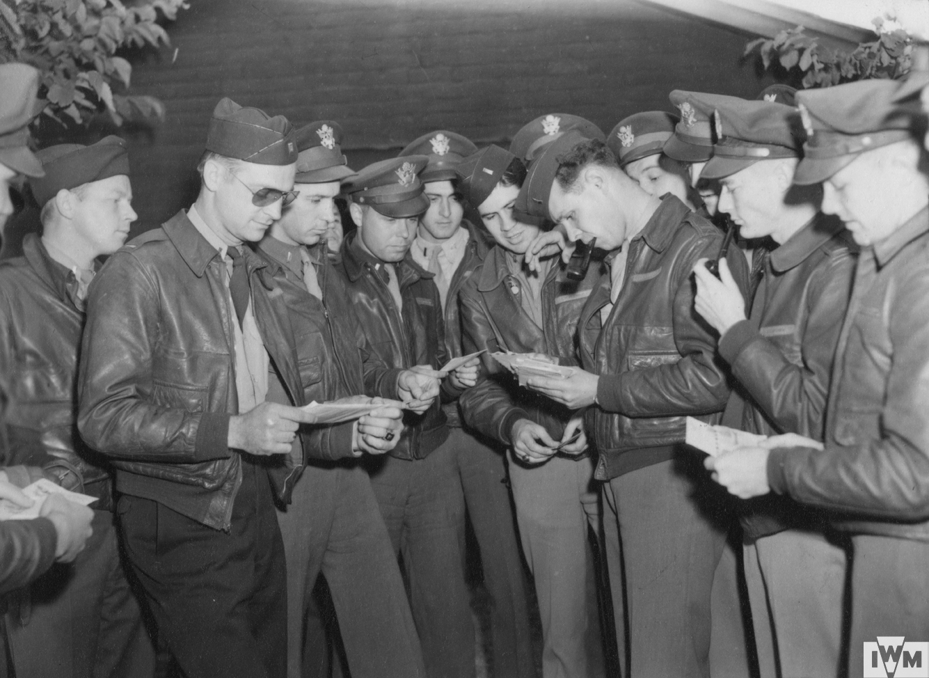 Lieutenant George T. Hartman (centre, with pipe) hands out mail to pilots of the 78th Fighter Group at Duxford air base.